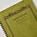 Close-up of Olive Apica CD Twin Ring Notebook cover showing textured finish and decorative border