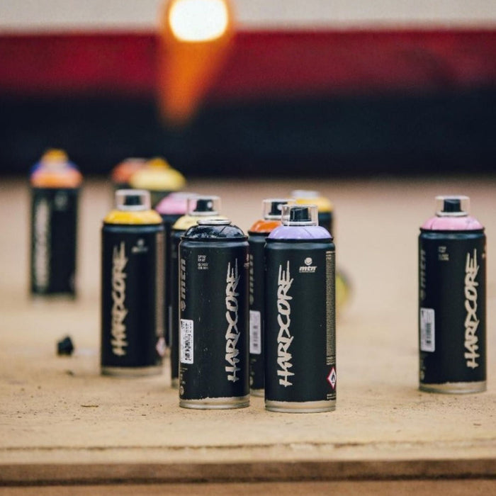 Assorted MTN Hardcore spray paint cans arranged on a studio work surface