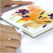 Artist removing finished sheet from Fluid Cold Press Watercolour Paper Easy-Block