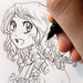  Manga-style line drawing being inked on sketch paper with a black pen