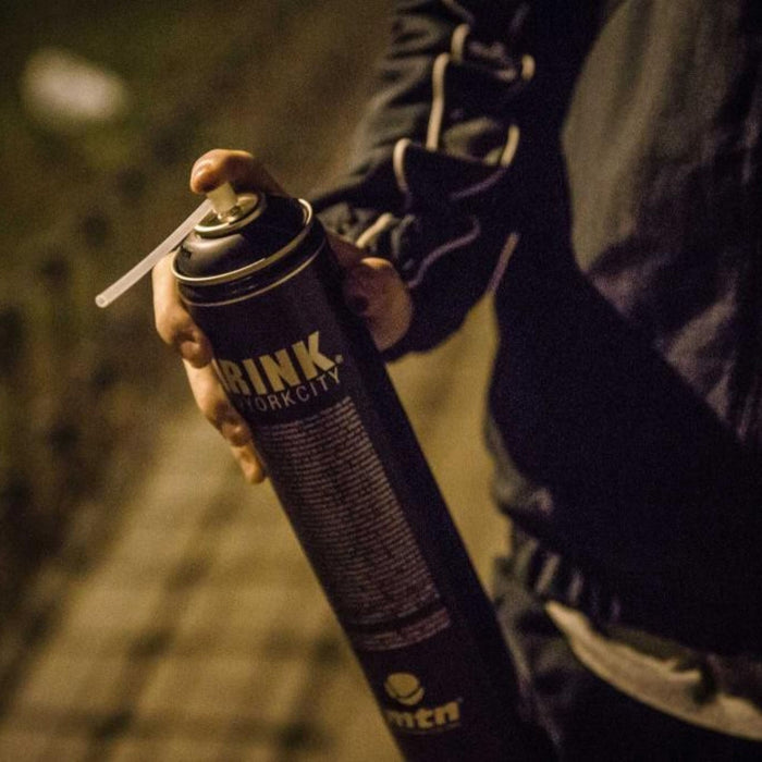 Artist holding MTN Krink K-750 spray paint can designed for long-distance graffiti and mural applications