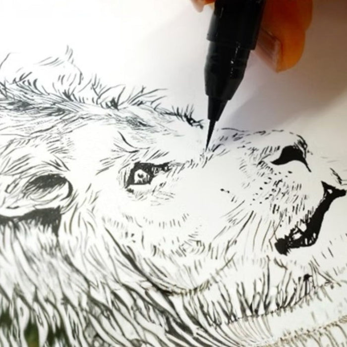 Close-up of ultra-fine brush pen adding details to a lion illustration