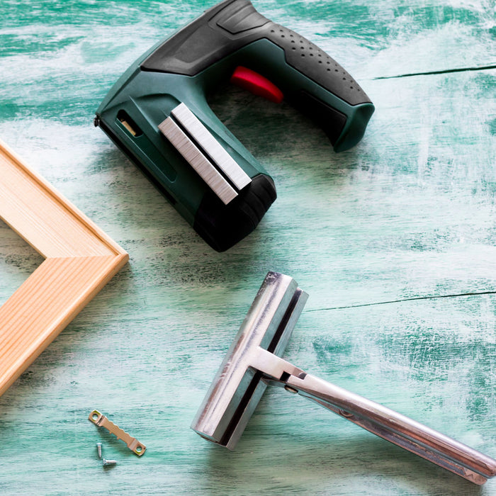 Canvas stretching pliers with staple gun and frame on work surface