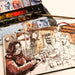 Watercolour sketchbook in use with paint palette, brush, and urban sketch illustration