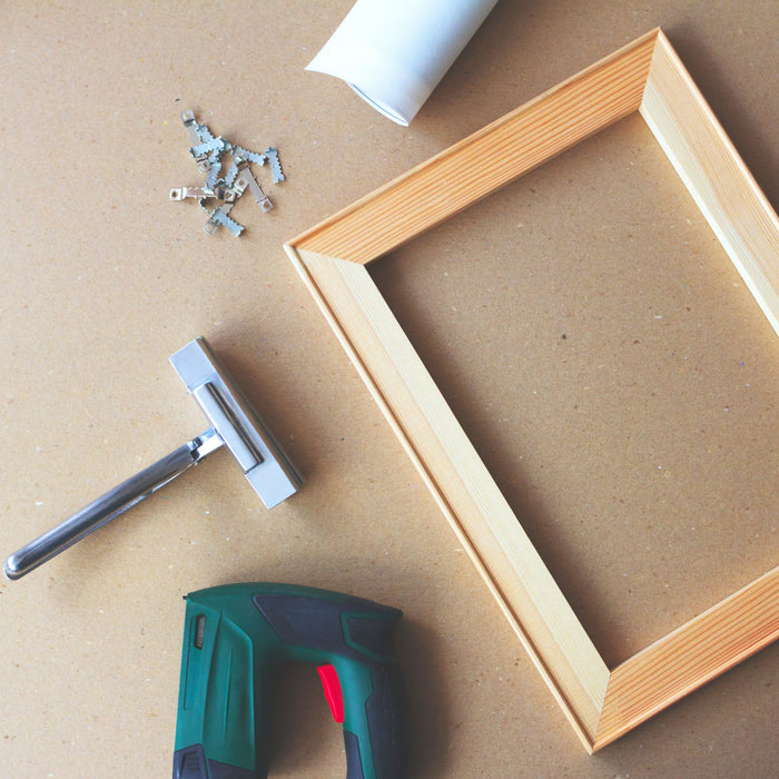 Canvas stretching tools beside wooden stretcher frame