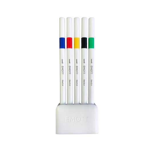 Five fineliners in a white desk stand. Colours blue, red, yellow, black, and green.