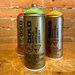 Three Montana Gold spray paint cans in green, yellow, and red in front of a brick wall.